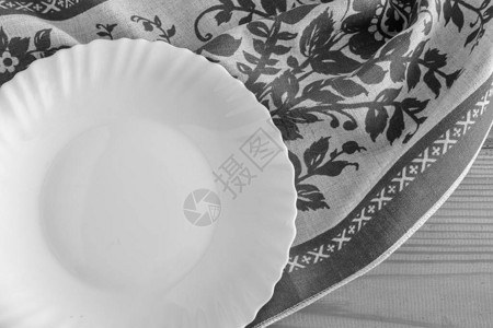 一个白色的空盘子放在亚麻餐巾上图片
