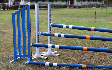在空的训练场上展示跳杆的图像跳马的木障碍作为背景马术障碍的彩色照片图片