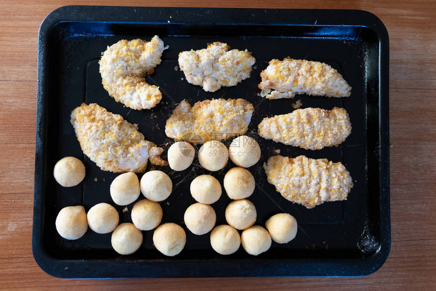 烹饪前冷冻面包鸡和炸小土豆球图片