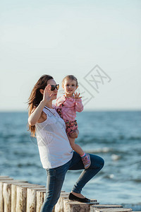 母亲和小女儿在沙滩上散步图片
