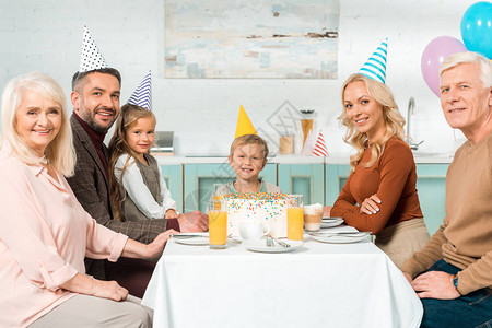 幸福的家庭坐在厨房餐桌边吃着生日蛋糕背景图片