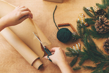 包装圣诞礼物的概念用剪刀和礼盒松枝锥体姜饼线肉桂剪刀在木图片