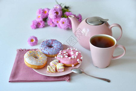 一杯茶和五颜六色的美味甜圈图片