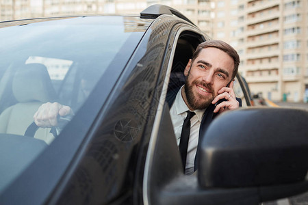 年轻快乐的商人驾驶汽车从窗外靠过窗在移图片