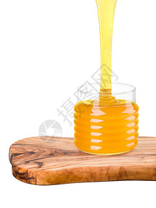 玻璃罐装满蜂蜜和掉落的蜂蜜喷射机图片