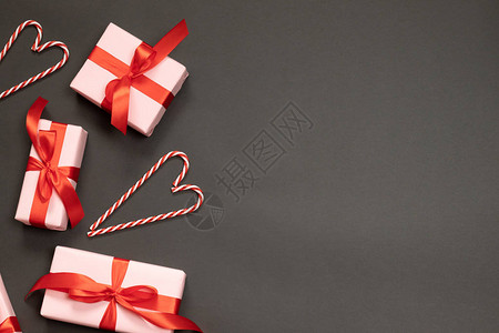 带有红丝带装饰的礼品盒暗底背景和文字位置的糖果甘蔗的创意构成图片