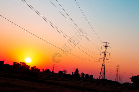 在美丽的日落天空背景高压电源传输线上图片