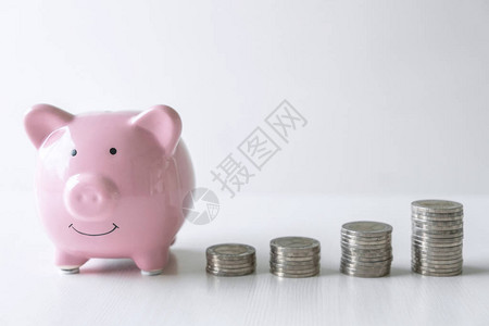 堆积硬币和粉红色微笑小猪银行的图象图片