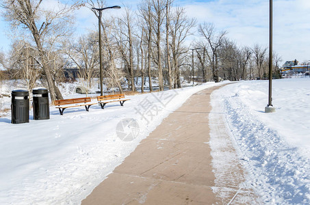 清空的河边一个雪地公园中的积雪通道在一个充满云图片