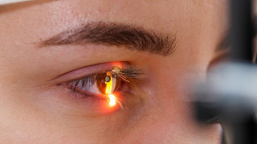 一位年轻女子用特别的大型测光仪棕色眼睛颜色检查她的视觉敏图片