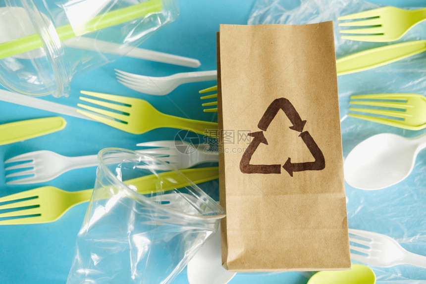 带有回收标志和一次使用一次餐具塑料污染废物的工艺纸袋图片