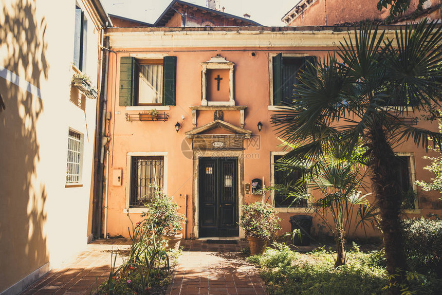 意大利威尼斯2017年7月14日美丽的风景如画的狭窄小巷与历史悠久的传统房屋和鹅卵石街道在欧洲老城与蓝天和云彩在夏天在图片