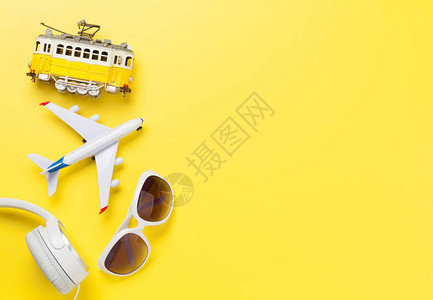 带有飞机玩具电车太阳眼镜和耳机的旅行概念背景顶端视图平面图片