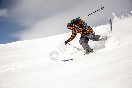 滑雪者穿着多彩运动服用滑雪棒和滑雪棍图片