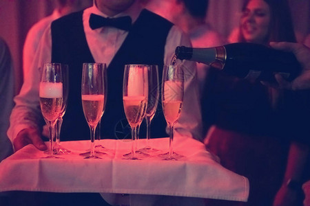 人为酒杯中的香槟饮料倒彩礼的盛宴活动图片
