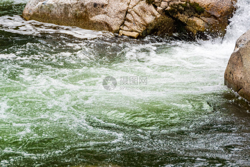 河流的岩石床流着滚动溪流的快山河在水图片