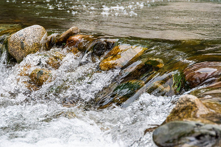 河流的岩石床流着滚动溪流的快山河在水图片