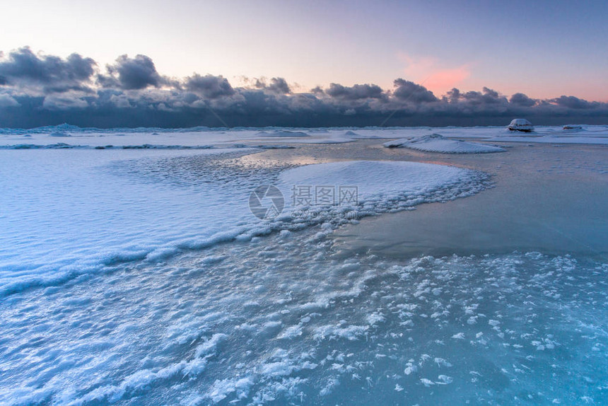 在日落时间的多雪的海岸图片