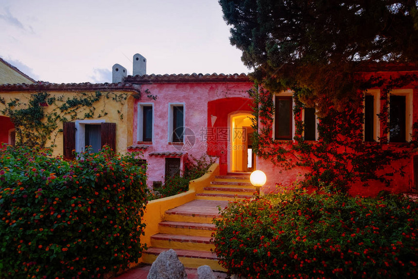 BajaSardinia豪华度假村的房屋在晚上在CostaSmeralda日落图片