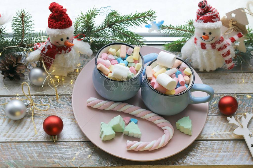 两杯饮料和棉花糖圣诞装饰木制窗台上的灯饰家庭舒适图片