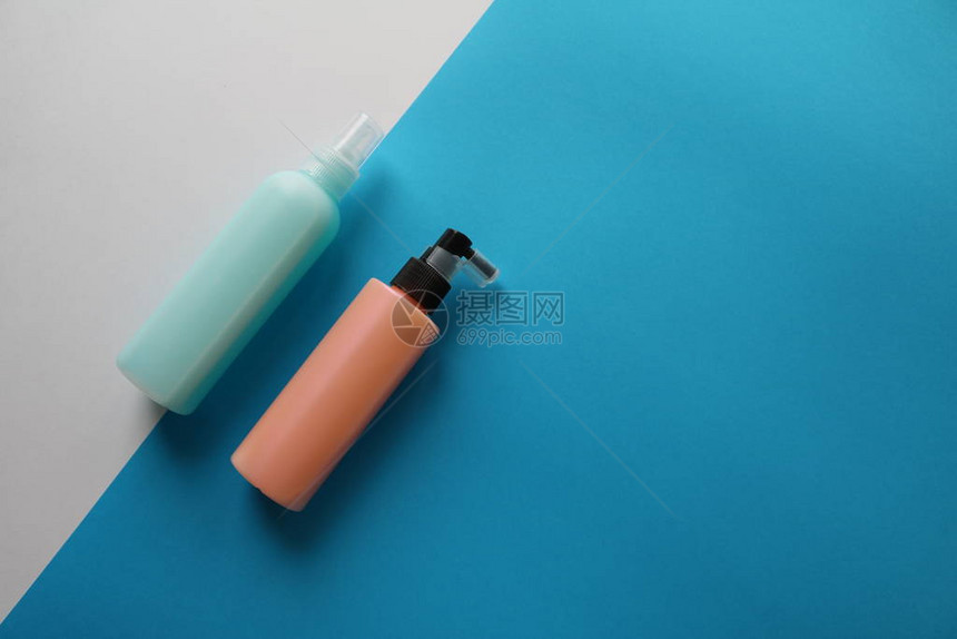 白色和蓝色背景上带有喷发胶的粉色和蓝色塑料瓶现代平躺皮图片