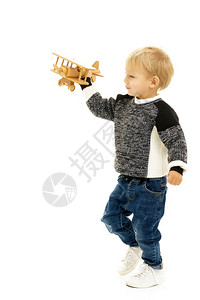 快乐的男孩玩木制玩具飞机孤图片