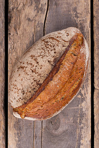 一条新鲜面包在木制背景上图片