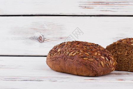 黑麦面包与木制背景上的种子葵花籽黑面包吃全麦面图片