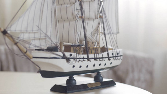 木制船玩具模型站在灯房的木制桌子上图片