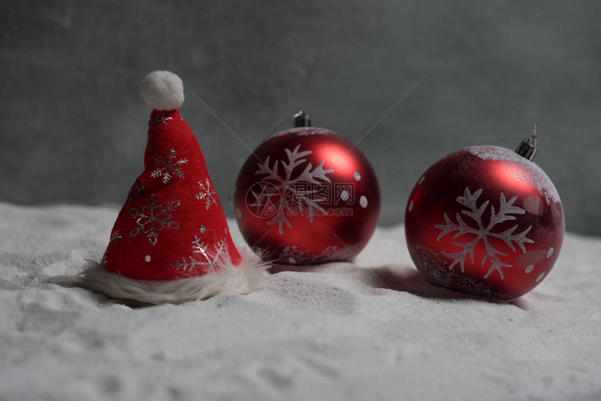 雪地上美丽的红色小玩意在暗金色背景灯的圣诞饰品创图片