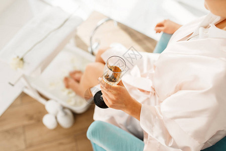 妇女利用徒步洗浴和喝香槟美容院专业美容服务女顾客在温泉疗养所的皮图片