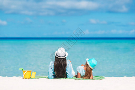 母亲和小孩在白色沙滩上放松图片