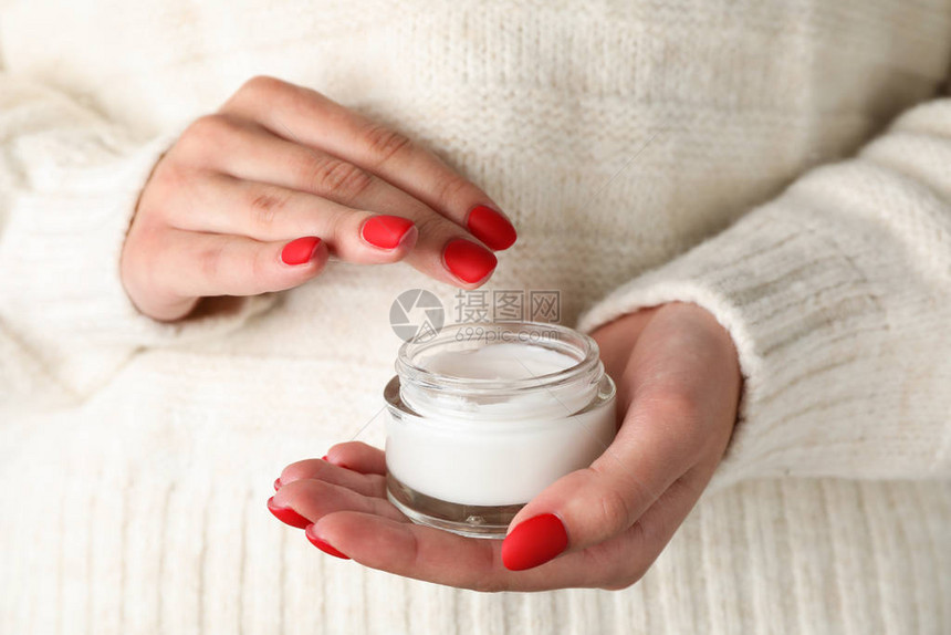 女人拿着一罐湿润奶油闭合冬季化妆图片