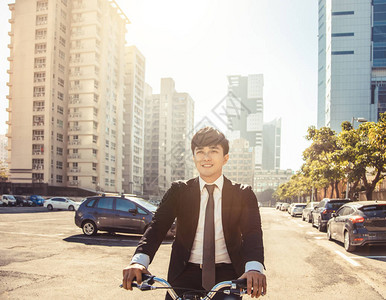 商人骑自行车上午在城市街道上工作背景图片