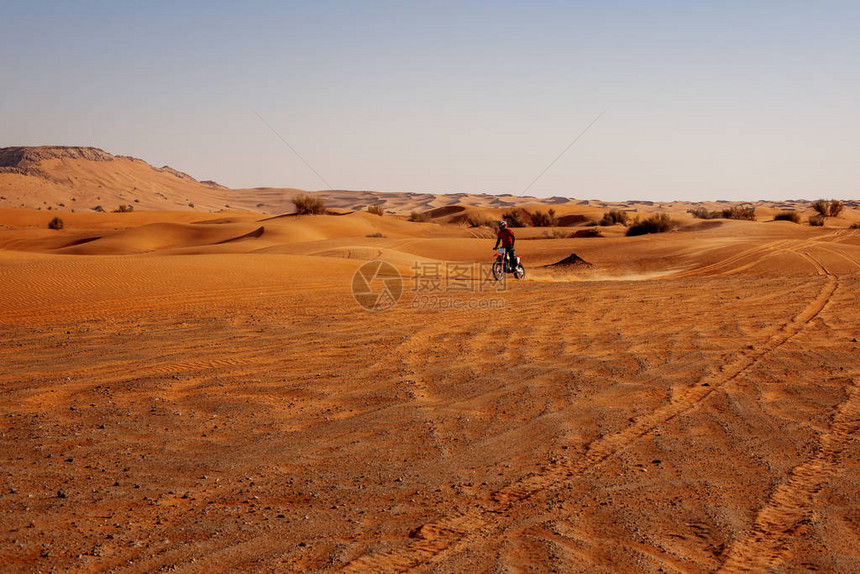专业越野摩托车司机在沙图片