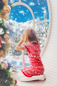 孩子看着冬天的窗外选择焦点图片