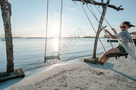 女人在马尔代夫豪华度假胜地的海边摇图片