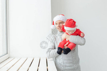 父亲和假期的概念父亲带着他的男婴戴着圣诞老人的帽图片