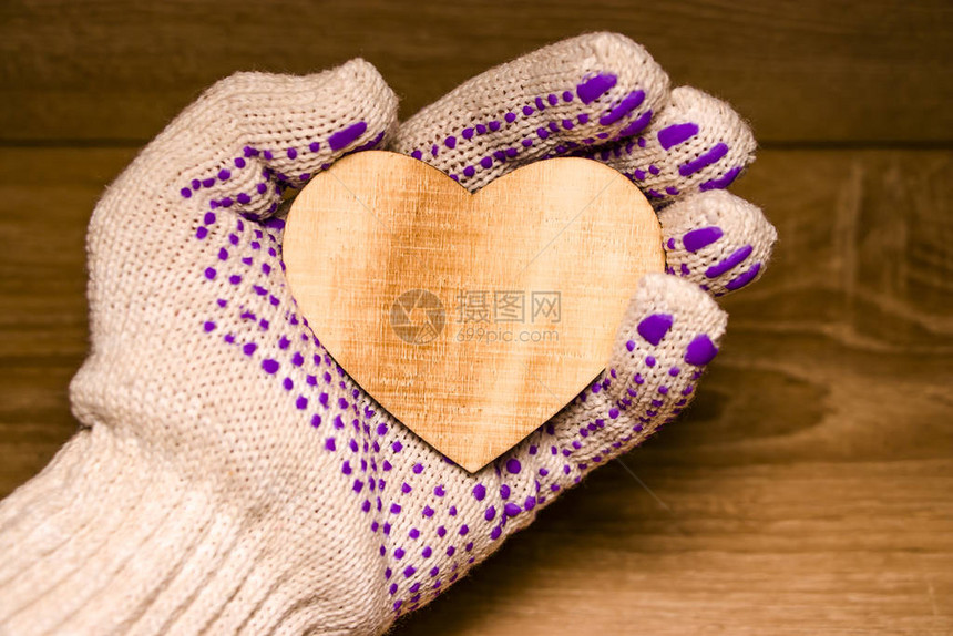 情人节红心用手套握在男手中用木制背图片