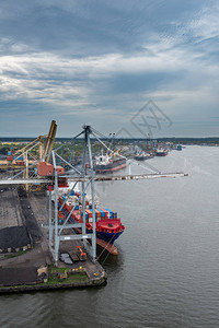 进出口业务和物流中的集装箱船用起重机将货物运送到港图片