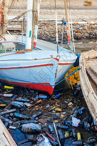 旧船停泊在肮脏的港口河流海洋海洋水与废物塑料垃圾的污染海洋海洋和河流海岸线与塑料垃图片