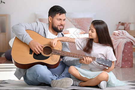 小女儿和爸在家弹吉他图片
