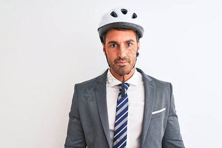 身着西装领带和自行车头盔的英俊年轻商人在孤立的背景面部露出严肃的表情图片