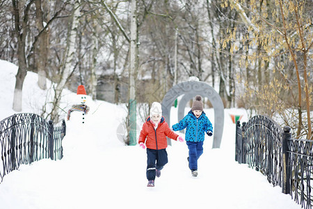 冬天公园里的孩子们孩子们在操场上玩雪他们雕刻雪背景图片