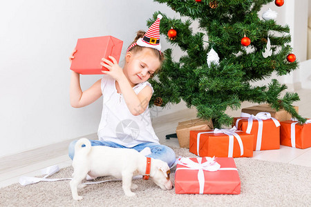 小孩打开Xmas礼物圣诞树下的图片