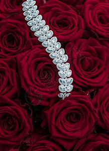 奢华品牌魅力时尚和精品购物理念奢华钻石珠宝手链和红玫瑰花情人节爱情礼物和珠宝品牌背景图片