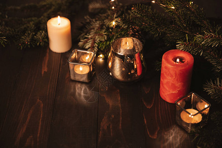 在旧木背景上点着小蜡烛和fir树枝的圣诞光图片