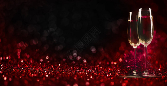 闪发光的红色散景背上的两个香槟杯庆祝吐司长笛情人节晚餐邀请圣诞节和图片