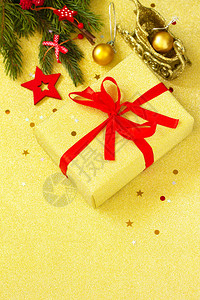 圣诞礼物盒是金盒配有红丝带和树枝装饰图片