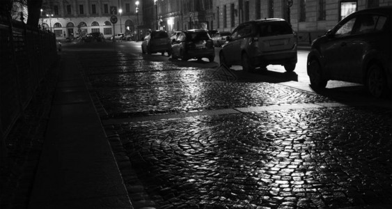 城市的雨天之夜潮湿闪亮的cobblestone路面加图片